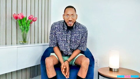 Cubbi Thompson sits casually in shirt and shorts for Dads on Set