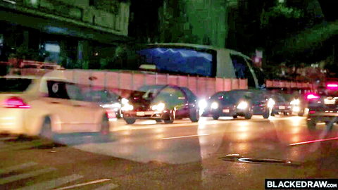 Blurry nighttime urban traffic jam with cars headlights taillights and BLACKEDRAW watermark