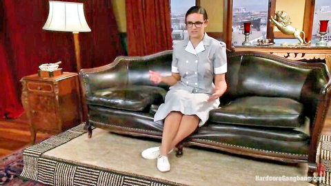 Sexy brunette nurse in tight uniform sitting seductively on couch gesturing with legs crossed