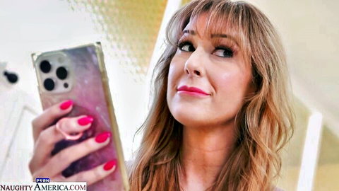 Seductive blonde MILF with plump lips taking selfie holding pink phone