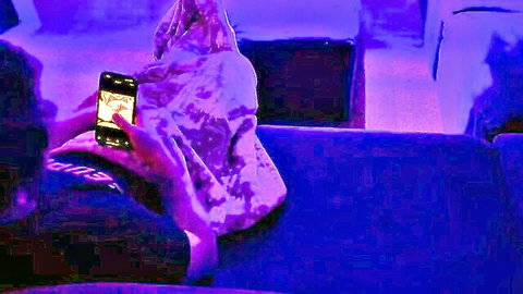 Hooded man watches young blonde with small tits finger her pussy on phone screen
