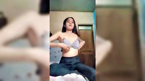 Petite Asian teen pulls open her light blue bra teasing small tits in homemade bedroom