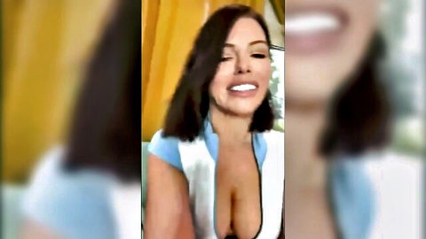 Adriana Chechik smiles seductively in low-cut white top showing cleavage