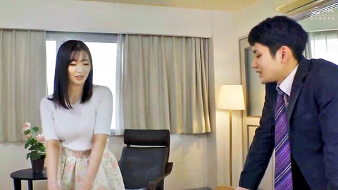 Mayu Suzuki as wife in white top and floral skirt facing suited man in JAV scene