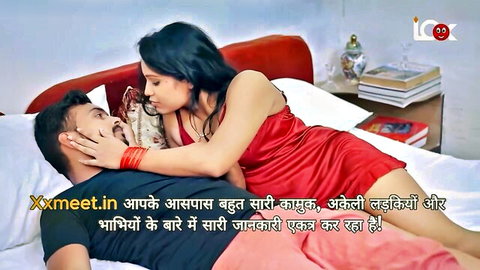 Indian woman in red dress straddling man in passionate embrace