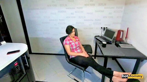 Busty MILF in plaid shirt sits with crossed legs, ready to help stepson