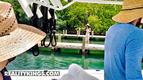 Valerica Steele in white dress on sunny boat dock with Jmac, outdoor tease