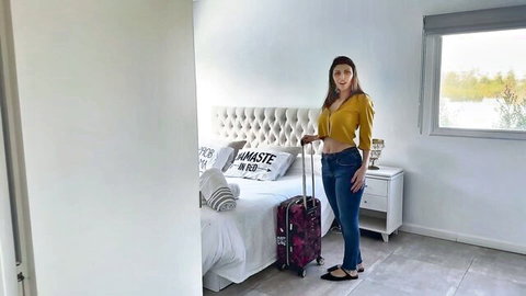 Curvy MILF packing suitcase for vacation in yellow crop top and tight jeans