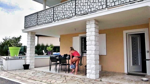Blonde in red bikini bending over teasing outdoors