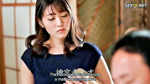 Submissive Japanese housewife with long brunette hair gazes intensely at man in intimate emotional close-up