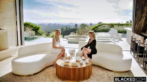 Holly Hotwife in elegant white dress with blonde friend on couch