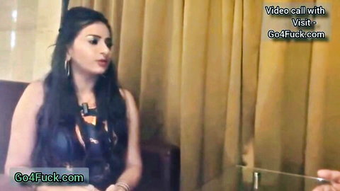 Seductive Indian MILF in tight black top smiling on hotel video call with GoFuck watermark