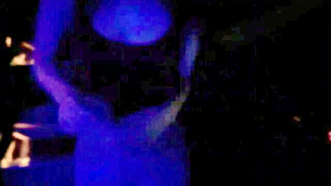 Blurry blue-lit motion blur of indistinct figures in dark scene, no clear action visible