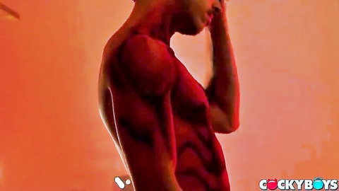 Muscular black stud poses seductively from behind in steamy red lighting