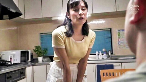 Asian wife in yellow crop top and white skirt teasing in kitchen