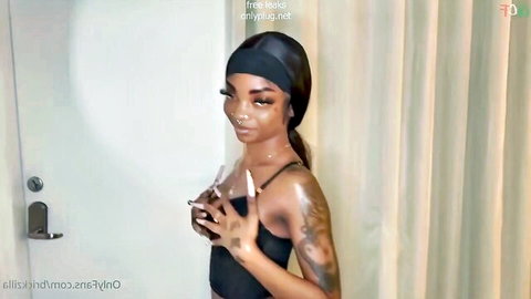 Sexy tattooed ebony babe in black headwrap teases with long nails and perky tits in tight top