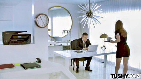 Skinny brunette secretary in tight red dress serves coffee to suited boss in modern office