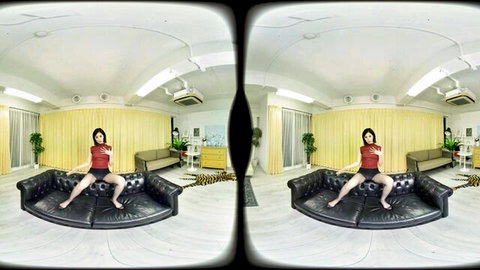 Japanese woman in red top sitting legs apart on couch in VR porn