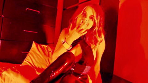 Coco Lovelock seductive pose in black latex dress and thigh-high boots
