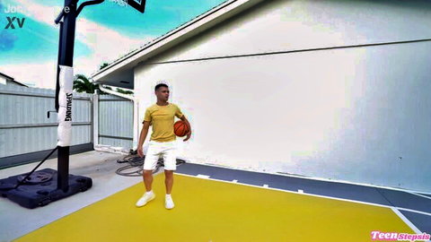 Athletic guy in yellow tee and white shorts holds basketball on outdoor yellow court pad