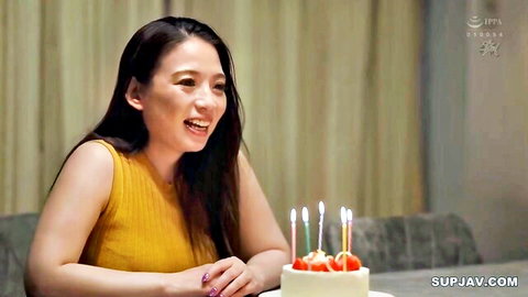 Mako Oda smiling at birthday cake in yellow sleeveless top