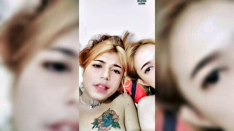 Blonde Asian woman with tattoos embraces brunette friend in intimate close-up