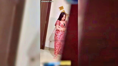 Indonesian hijab-wearing busty woman in red dress posing seductively