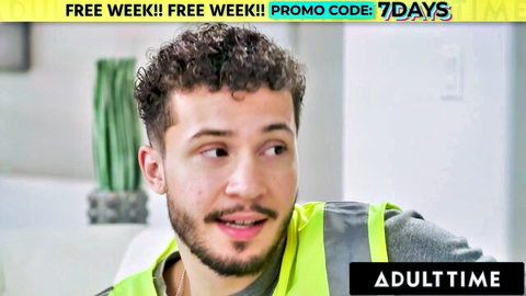 Handsome curly-haired man in yellow vest smiling for AdultTime free week promo code 7DAYS