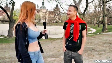 Scarlett Jones redhead in blue crop top with deep cleavage interviewing guy in park