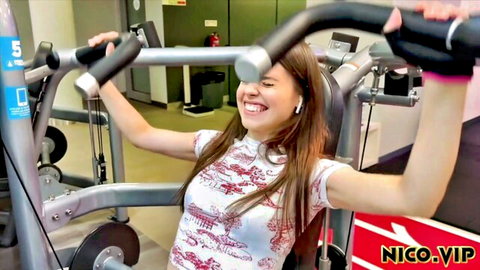 Jamie Young smiling on gym chest press machine in fitted white top