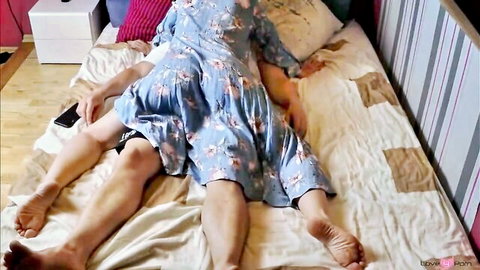 Passionate stepmom in blue floral dress spreads legs wide for stepson missionary fuck on bed