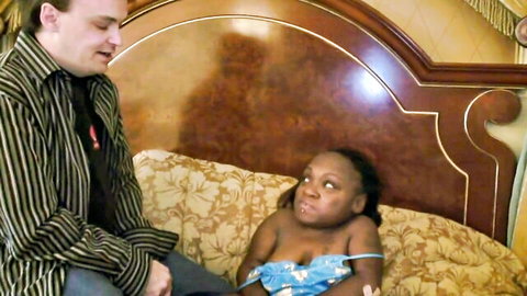 Vintage interracial scene with petite black woman and white man on bed