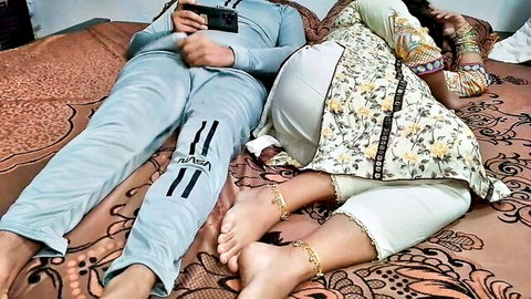 Indian stepmom in salwar kameez spoons stepson on bed, feet with anklets teasing intimately