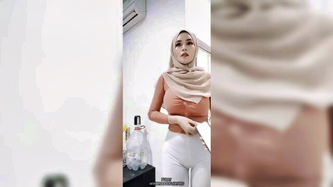Beautiful hijab woman in tight beige top and white pants posing seductively