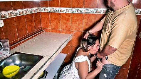 Brunette woman in white dress kneels for intense kitchen blowjob on boss