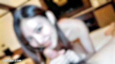 Smiling Asian woman cupping her breasts in close-up nude pose
