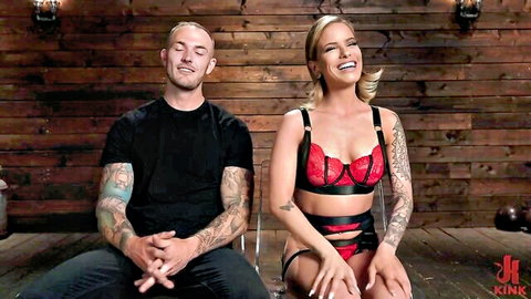 Tattooed blonde in red lingerie posing with tattooed man, seductive couple thumbnail