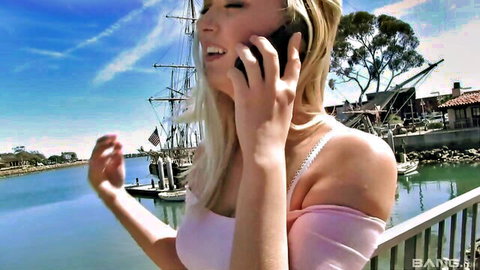 Natalia Starr smiling on phone call in pink off-shoulder top by marina