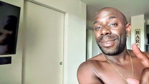Shirtless Joss the BBC smiling confidently in bedroom