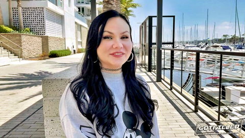 Brynn Michaels smiling in gray sweatshirt by marina, teasing outdoor vibe