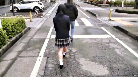 Japanese schoolgirl in plaid skirt and uniform walking with guy on rainy street