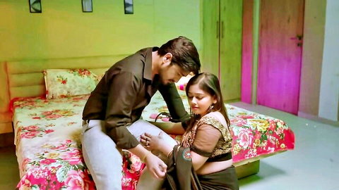 Indian couple in intimate saree embrace on bed from Hindi web series