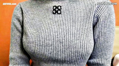 Busty babe in tight gray turtleneck sweater showing deep cleavage tease