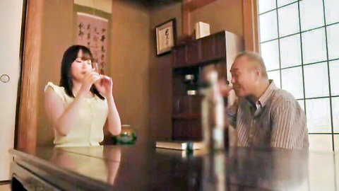 Japanese woman in yellow top drinks sake with older father-in-law