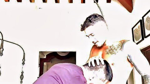 Tattooed muscular hunk roughly dominating bent-over partner in gay encounter