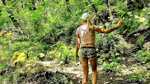 Tattooed woman masturbating with dildo outdoors in woods
