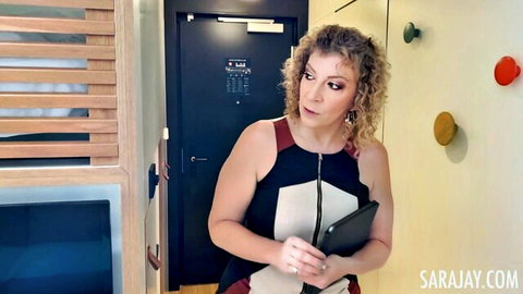 Curvy Sara Jay in sexy manager dress holding tablet