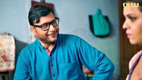 Smiling Indian man in glasses eyes seductive South Asian woman in pink dupatta close-up Ullu episode