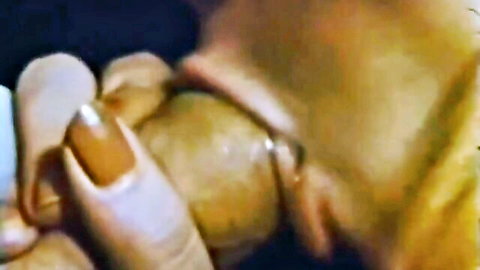 Vintage close-up of woman with orange nails flicking erect penis in classic XXX scene