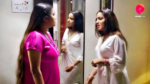 Curvy Indian women in tight pink top and white satin robe chatting seductively by mirror